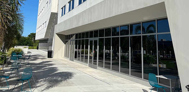 A photo of the Ponce Health Sciences University showing a three story beige concrete building.